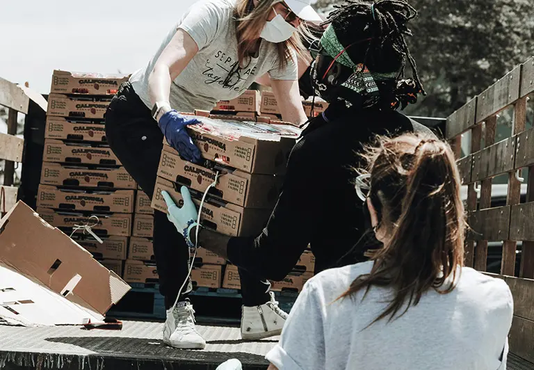 3 individuals helping each other with boxes